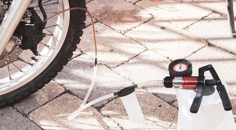 Oude vloeistof zuigen we door de leiding met een vacuümpomp